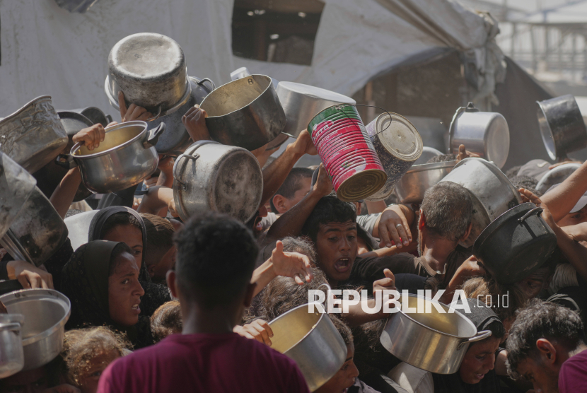 Warga Palestina berebut untuk mendapatkan makanan dari dapur umum di Khan Younis, Jalur Gaza, Jumat (9/5/2025). Warga Gaza harus berebut untuk mendapatkan makanan dari dapur umum. Menipisnya pasokan membuat tak semua warga Gaza bisa mendapatkan makanan. Blokade Israel yang terus berlanjut terhadap bantuan kemanusiaan untuk Gaza, membuat dapur umum tutup karena tidak ada pasokan bahan pangan. Bencana kelaparan mengancam ratusan ribu warga Palestina.
