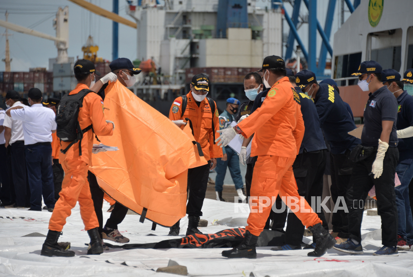 Petugas Tim SAR Gabungan menurunkan kantong jenazah korban pesawat Sriwijaya Air SJ 182 dari kapal KM SAR Basudewa di Dermaga JICT 2, Tanjung Priok, Jakarta, Senin (11/1). Foto : Edwin Putranto/Republika