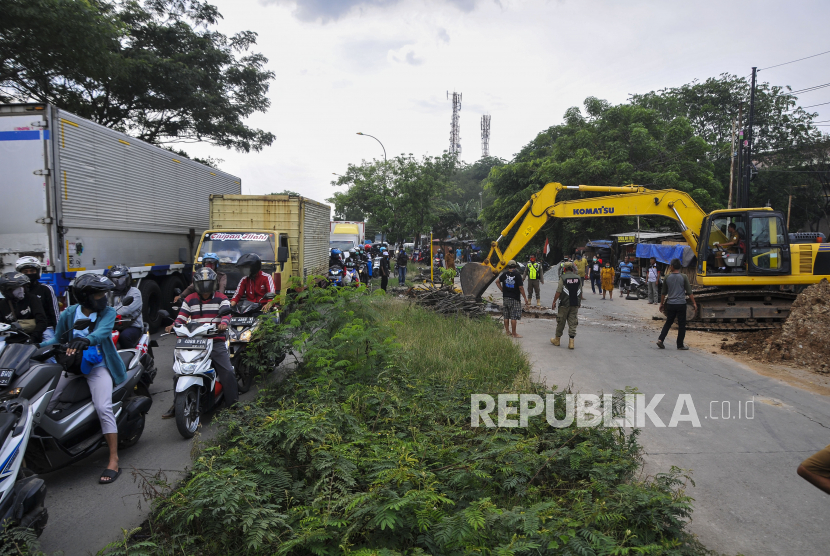 Sejumlah petugas gabungan dari Dinas Perhiubungan, Dinas PUPR dan Polri menggunakan alat berat eskavator melakukan sterilisasi Jalan Raya Inspeksi Kalimalang, Cikarang, Kabupaten Bekasi, Jawa Barat.