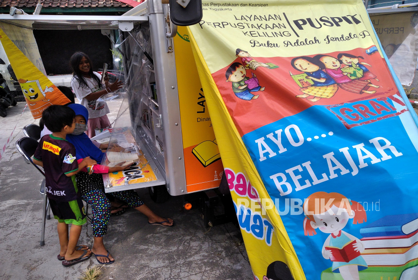 Anak-anak membaca buku di layanan perpustakaan keliling Puspita dari Perpustakaan Kota Yogyakarta di Ngampilan, Yogyakarta, Kamis (9/7). Anak-anak termasuk dalam kelompok rentan yang harus mendapat perlindungan esktra dari dampak pandemi Covid-19.