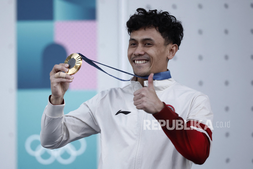 Atlet panjat tebing putra Indonesia Veddriq Leonardo memegang medali seusai mengalahkan atlet China Wu Peng pada final nomor speed putra Olimpiade Paris 2024.