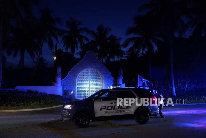  Polisi berdiri di luar pintu masuk ke perkebunan Mar-a-Lago mantan Presiden Donald Trump, Senin, 8 Agustus 2022, di Palm Beach, Florida. Trump mengatakan dalam sebuah pernyataan panjang bahwa FBI sedang melakukan penggeledahan atas Mar-a-Lago miliknya. Lago estate dan menegaskan bahwa agen telah membuka brankas.