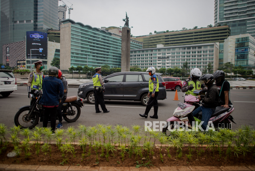 Petugas gabungan dari Kepolisian Polda Metro Jaya dan Dinas Perhubungan Pemprov DKI Jakarta melakukan penindakan pelanggaran Pembatasan Sosial Berskala Besar (PSBB) di kawasan Bundaran HI, Jakarta.