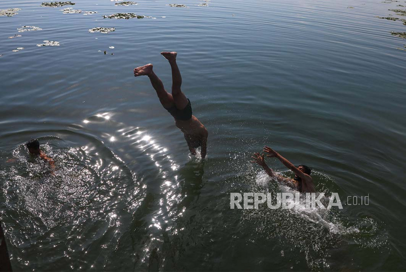 Warga Kashmir berenang di Danau Dal untuk mengatasi panas, di Srinagar, ibu kota musim panas Kashmir India.