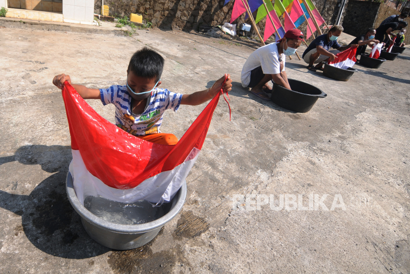 Sejumlah warga mencuci bendera Merah Putih bersama di Beji, Sidomulyo, Ampel, Boyolali, Jawa Tengah, Ahad (8/8/2021). Kegiatan mencuci bendera Merah Putih bersama tersebut sebagai cara warga setempat untuk menjaga rasa nasionalisme dalam menyambut HUT ke-76 Republik Indonesia. 