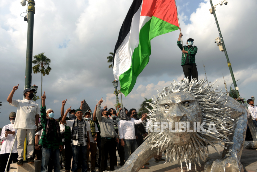 Massa aksi Forum Umat Islam (FUI) mengibarkan bendera Palestina saat unjuk rasa di Titik Nol Yogyakarta (ilustrasi).