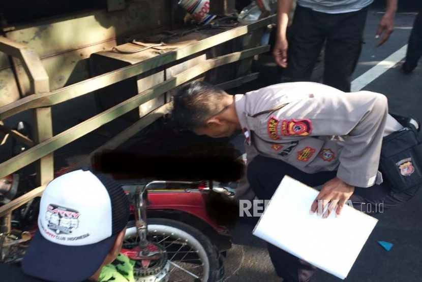 Polisi mengecek kecelakaan lalu lintas yang melibatkan pengendara motor dan truk di ruas Jalan Cisaga-Rancah, Kecamatan Cisaga, Kabupaten Ciamis, Jawa Barat, Kamis (30/3/2023). 