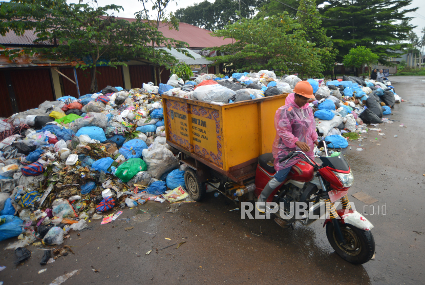 Pekerja membuang sampah di tempat pembuangan sampah sementara (ilustrasi).