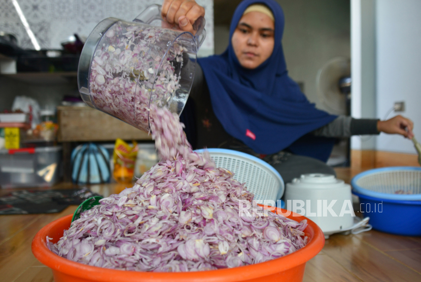Pekerja mempersiapkan bawang merah iris saat proses produksi bawang goreng di salah satu home industri, Desa Lampeunerut, kecamatan Darul Imara, Kabupaten Aceh Besar, Aceh, Sabtu (1/5/2021). Mengiris bawang merah bisa membuat mata berair.