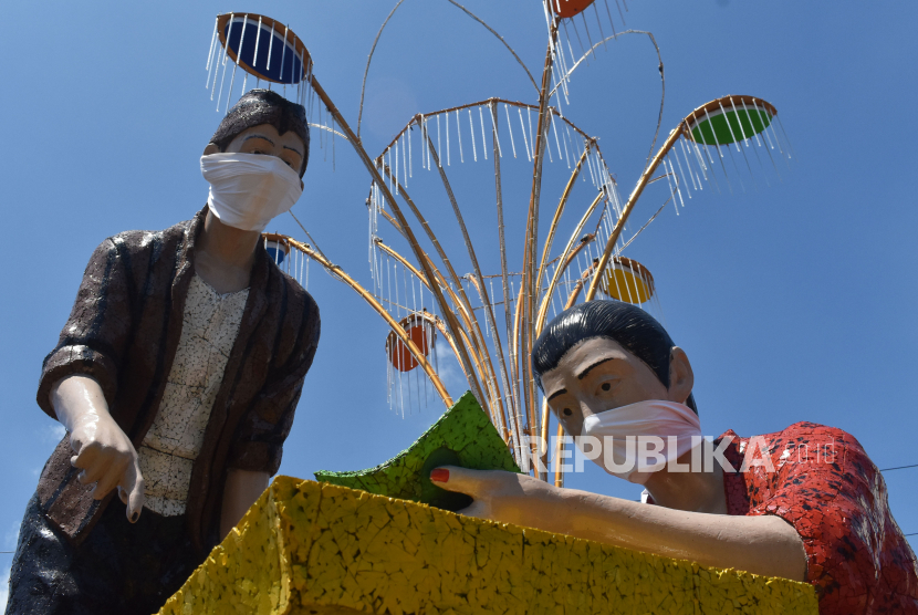 Patung penjual nasi pecel mengenakan masker di Kota Madiun, Jawa Timur, Jumat (10/04/2020). Pemkot Madiun akan memasang masker pada semua patung yang ada di wilayah itu sebagai salah satu bentuk kampanye penggunaan masker bagi masyarakat guna mencegah penularan COVID-19