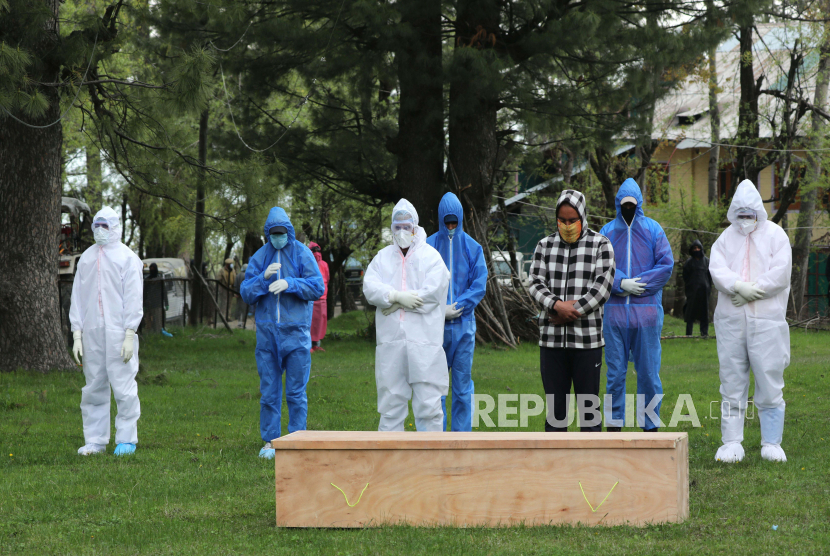 Staf medis dan kerabat berdoa di dekat peti mati pria berusia 72 tahun yang meninggal karena Covid-19 di Tangmarg, sekitar 30 kilometer utara Srinagar, Kashmir, India, Sabtu (25/4). Pemerintah Kashmir yang dikelola Pakistan mengumumkan lockdown kembali. Ilustrasi.