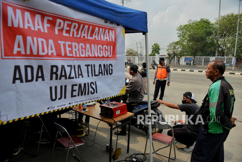 Petugas gabungan menindak pengendara pada saat razia tilang uji emisi di kawasan Cakung, Jakarta. Baru satu hari diterapkan di DKI Jakarta, sanksi tilang uji emisi kembali ditiadakan.