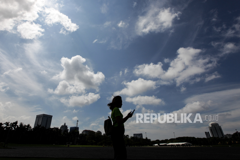 Siluet warga saat berwisata di kawasan Monumen Nasional, Jakarta, Kamis (21/3/2024). 
