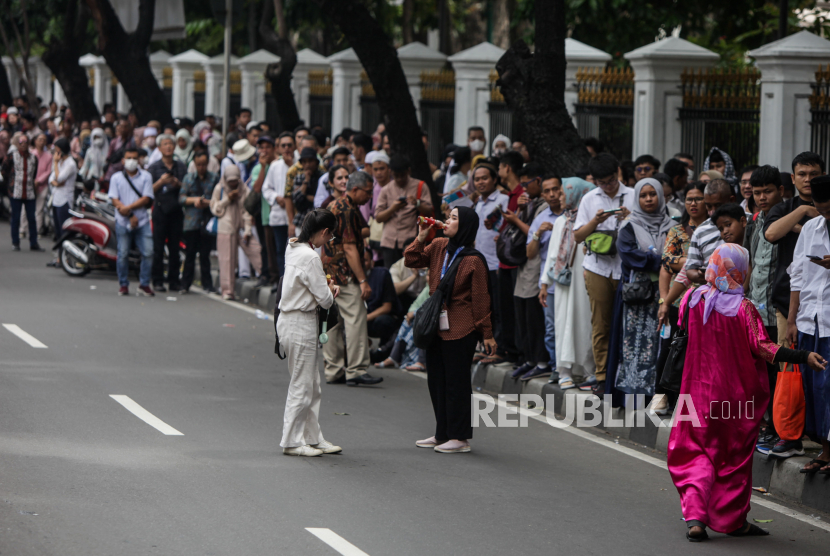 Sejumlah warga mengantre untuk menghadiri open house yang diselenggarkan Presiden Joko Widodo di depan Kantor Kementerian Sekretariat Negara, Jakarta, Rabu (10/4/2024). Ratusan warga rela mengantre sejak pagi hari untuk bersalaman dengan Presiden Joko Widodo di Istana Negara pada momen Idul Fitri 1445 Hijriah di periode akhir kepemimpinannya.
