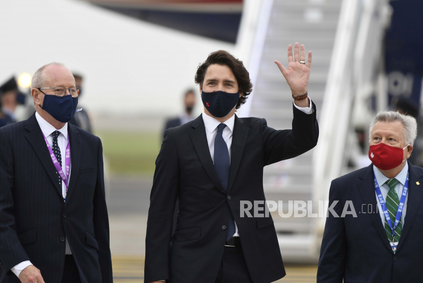 Perdana Menteri Kanada Justin Trudeau, tengah, melambaikan tangan saat tiba menjelang pertemuan G7 di bandara Cornwall di Newquay, Cornwall, Inggris, Kamis, 10 Juni 2021. Para pemimpin dan tamu G7 akan bertemu di resor Cornish di Carbis Bay mulai Jumat , 11 Juni 2021.