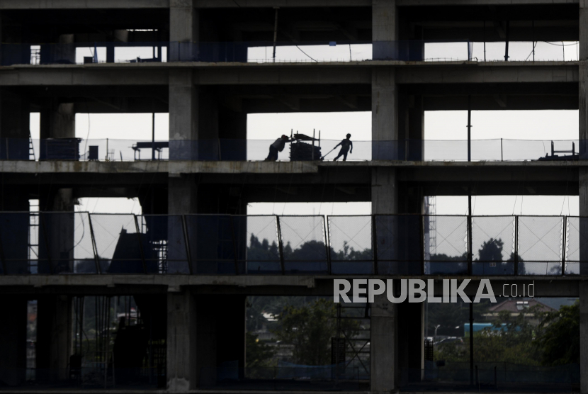 Pekerja menyelesaikan pembangunan gedung bertingkat di Jakarta, Senin (28/11/2022). PBB melaporkan kejahatan perdagangan orang menurun selama pandemi.