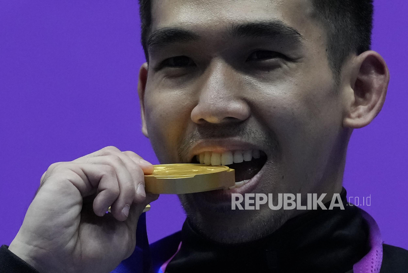 Pewushu Indonesia Harris Horatius menggigit medali emas usai final nomor nangun putra Asian Games 2022 di Xiaoshan Guali Sports Centre, Hangzhou, China, Selasa (26/9/2023). Harris Horatius berhasil meraih emas usai meraih total poin 19,506 (nanquan 9,756 poin dan nangun 9,750 poin). 