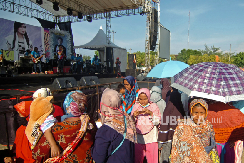 Sejumlah warga tidak mengenakan masker menyaksikan musik dangdut di Lapangan Tegal Selatan, Tegal, Jawa Tengah, Rabu (23/9/2020). Konser musik dangdut yang diadakan Wakil Ketua DPRD Kota Tegal Wasmad untuk perayaan pernikahan di tengah pandemi COVID-19 tersebut dihadiri banyak warga yang tidak menerapkan protokol kesehatan dengan tidak memakai masker dan tidak jaga jarak.