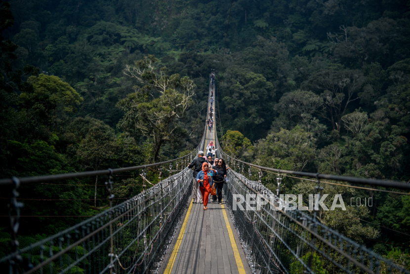 Pengunjung menyeberangi jembatan gantung rengganis di Patengan, Rancabali, Kabupaten Bandung, Jawa Barat, Selasa (8/8/2023). Jembatan Gantung Rengganis yang memiliki panjang mencapai 370 meter, lebar dua meter serta berada di ketinggian 150 meter dari tanah tersebut merupakan jembatan gantung terpanjang di Asia Tenggara.  