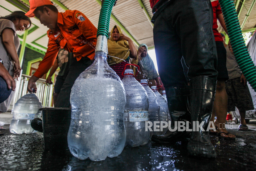 Petugas saat mendistribusikan air bersih kepada warga (ilustrasi).