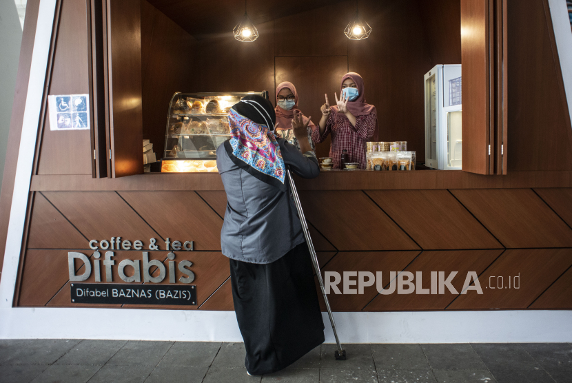 Pedagang difabel melayani pembeli di kedai Difabis Coffee & Tea, kawasan Terowongan Kendal, Jakarta Pusat, Selasa (26/1/2021). 