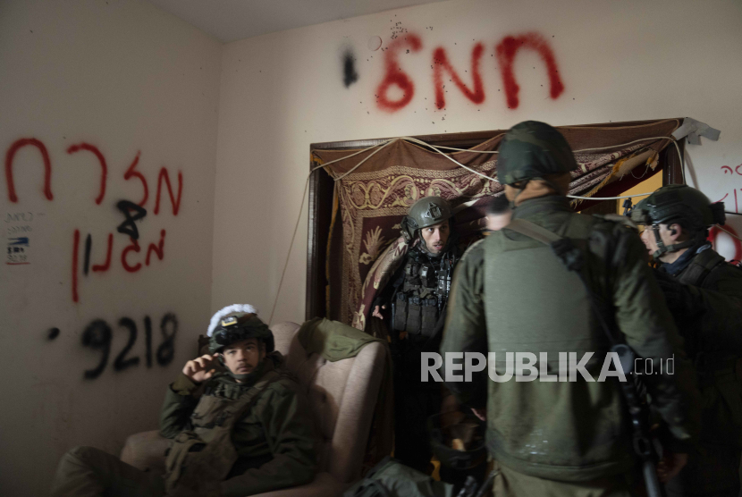 Tentara Israel berdiri di dalam gedung selama serangan darat di Jalur Gaza di Khan Younis, Sabtu, (27/1/2024). 