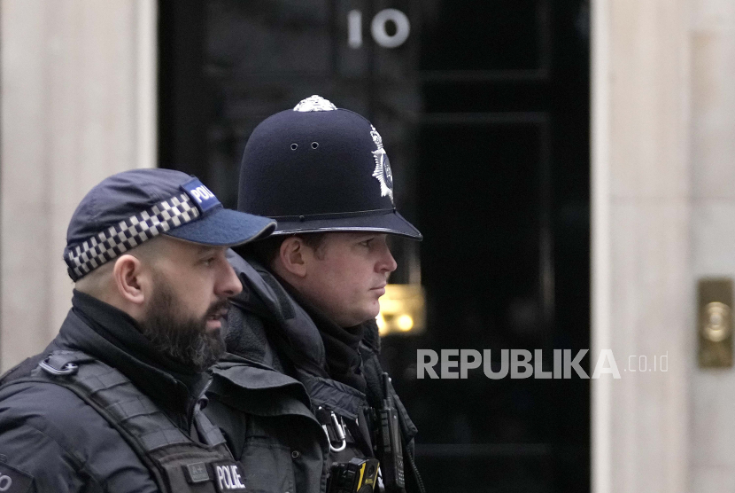 Petugas polisi berjalan melewati 10 Downing Street di London, Rabu, 26 Januari 2022. etugas polisi London mengaku bersalah atas 24 pemerkosaan sepanjang dua dekade. David Carrick menjadi salah satu pelaku pelecehan seksual paling produktif di Inggris.