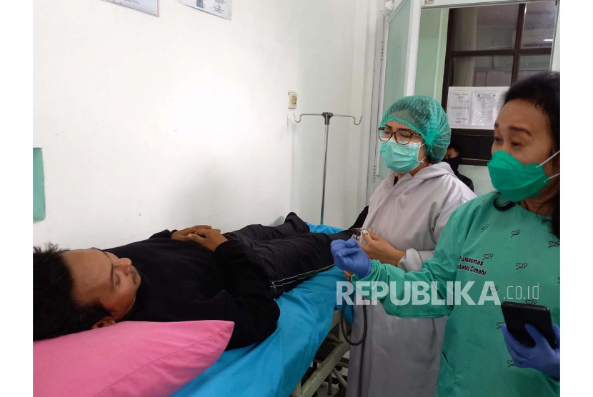 Petugas memeriksa kondisi pasien yang diduga mengalami keracunan makanan di Puskesmas Padasuka, Kota Cimahi, Jawa Barat, Senin (24/7/2023). 