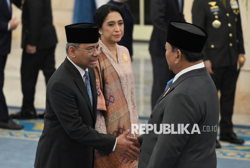 Presiden Prabowo Subianto (kanan) menyalami pejabat baru Menteri Keuangan Suahasil Nazara (kiri) yang didampingi istri Christina Pusporini Messakh (tengah) usai pelantikan di Istana Negara, Jakarta, Senin (14/9/2026). 