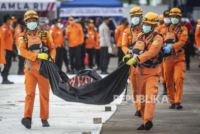 Personel Basarnas mengangkat kantong jenazah berisi objek temuan dari lokasi jatuhnya pesawat Sriwijaya Air PK-CLC nomor penerbangan SJ 182 rute Jakarta-Pontianak pada hari keenam Operasi SAR pesawat tersebut di Dermaga JICT, Tanjung Priok, Jakarta Utara, Kamis (14/1/2021). 