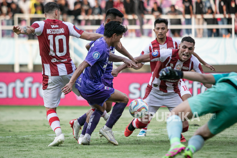 Persita Tangerang footballer Fahreza Sudin (second left) when he scored against Persis Solo against Jaimerson Da Silva Xavier (right) and Alexis Nahuel Messidoro (left) during a BRI Liga I match at Manahan Stadium, Solo, Central Java, Friday (26/4/2024). Persita Tangerang won over Persis Solo with a score of 2-1.