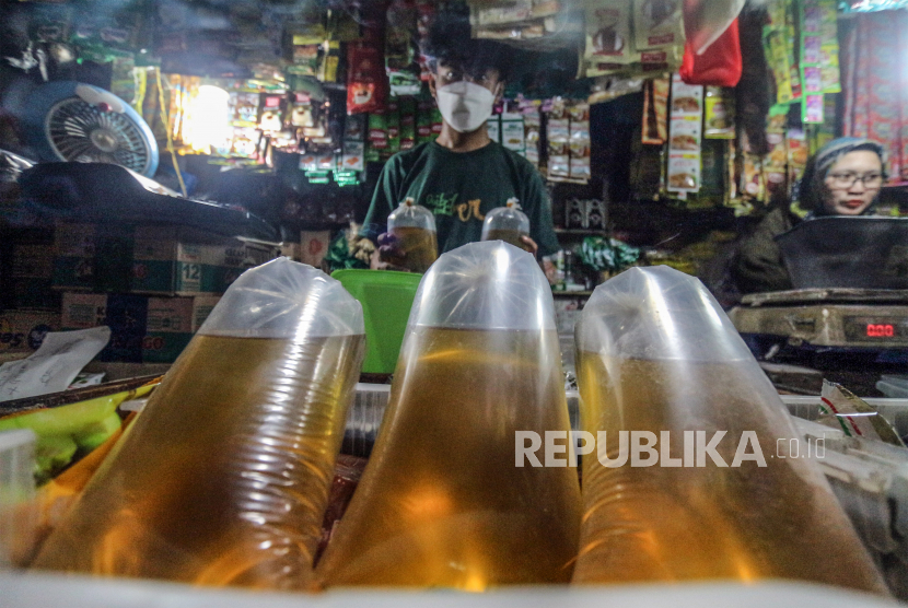 Pedagang menata minyak goreng curah yang dijual di Pasar Cibinong, Kabupaten Bogor, Jawa Barat, Rabu (16/3/2022). Menteri Perdagangan Muhammad Lutfi menerbitkan aturan kenaikan Harga Eceran Tertinggi (HET) minyak goreng curah jadi Rp14.000 per liter yang sebelumnya Rp11.500 dan berlaku sejak Rabu (16/3/2022). 