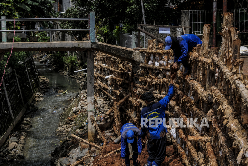 Sejumlah petugas memperbaiki turap yang longsor di kawasan Batu Ampar, Kramat Jati, Jakarta, Rabu (24/2). Indonesia mengalami kejadian bencana hingga 3.253 kali dalam kurun waktu setahun, sejak Februari 2020 sampai Februari 2021.
