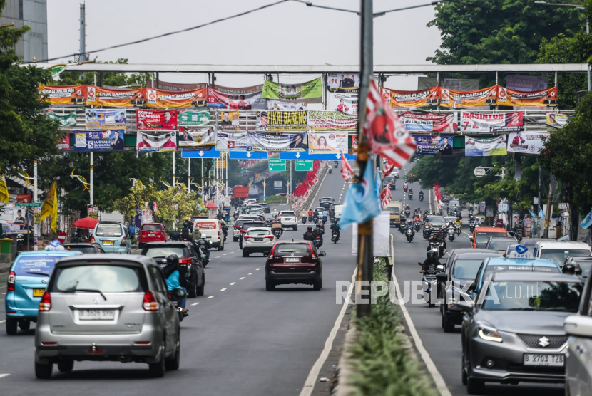 Kendaraan melintas di bawah Jembatan Penyeberangan Orang (JPO) yang tertutup oleh alat peraga kampanye Pemilu 2024 di Jakarta, Rabu (27/12/2023). 