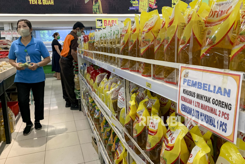  Seorang karyawan supermarket berjalan melewati rak minyak goreng di sebuah supermarket di Denpasar, Bali. Pemerintah akan memasok minyak goreng seharga Rp14 ribu per liter di supermarket. Ilustrasi.