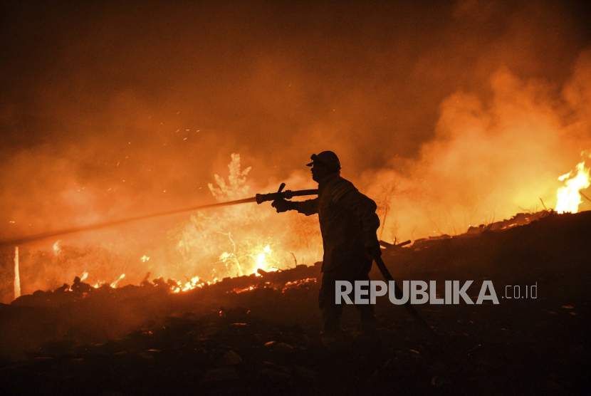  Seorang petugas pemadam kebakaran berjuang dengan api di desa Kirli dekat kota Manavgat, di provinsi Antalya, Turki Jumat pagi 30 Juli 2021.