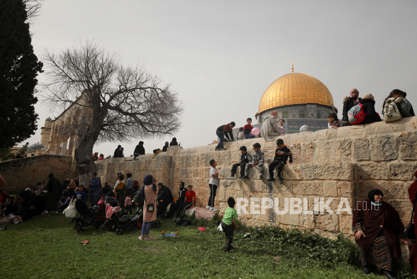 Orang-orang menghadiri perayaan Isra dan Miraj, yang menandai kenaikan Nabi Muhammad, di kompleks yang dihormati oleh orang-orang Yahudi sebagai Temple Mount dan Muslim sebagai Tempat Suci di Kota Tua Yerusalem pada 11 Maret 2021. The Dome of the Rock terlihat di latar belakang. 