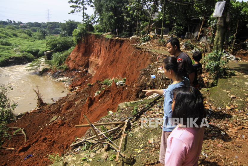 Sejumlah warga melihat jalan yang longsor di Kawasan Pasir Putih, Depok, Jawa Barat, Senin (8/11/2021). Hujan lebat yang mengguyur wilayah Pasir Putih Depok pada Minggu (7/11) tersebut menyebabkan terjadinya longsor yang mengancam permukiman warga di kawasan itu. 