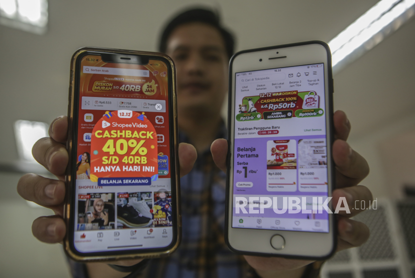 Warga menunjukan promosi potongan harga Hari Belanja Online Nasional (Harbolnas) di aplikasi belanja daring di Jakarta, Selasa (12/12/2023). 