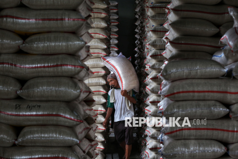 Pekerja mengangkut beras di Pasar Induk Beras Cipinang, Jakarta, Senin (14/7/2025). Masyarakat diimbau lebih waspada dalam membeli beras, hal ini menyusul temuan Kementerian Pertanian terkait 212 merek beras yang beredar di pasaran diduga melakukan pengoplosan, pelanggaran standar mutu, berat, hingga harga eceran tertinggi (HET).