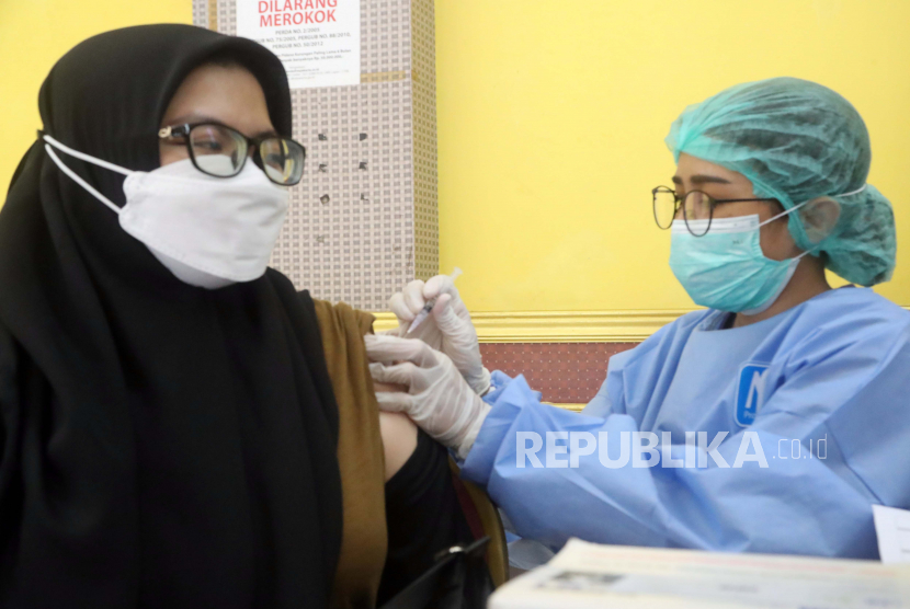 Seorang petugas kesehatan Indonesia memberikan dosis vaksin COVID-19 kepada rekan kerjanya selama kampanye vaksinasi booster COVID-19 di Jakarta, Indonesia, 02 Agustus 2022. Pemerintah Indonesia memulai dosis keempat vaksin COVID-19 untuk petugas kesehatan di tengah kekhawatiran tentang penyebaran varian COVID-19 baru.