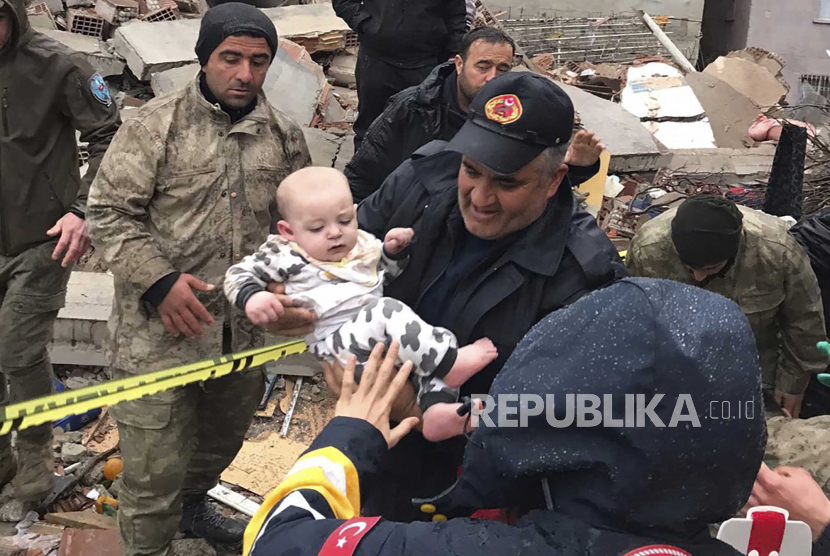 Seorang bayi diselamatkan dari bangunan yang hancur di Malatya, Turki, Senin, (6/2/2023). 