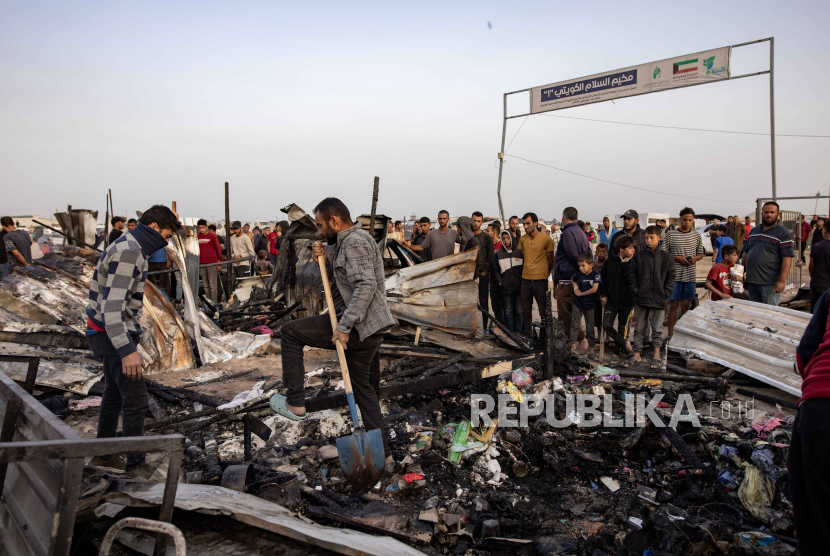 Warga Palestina berada di puing-puing akibat serangan Israel di Kamp Pengungsian Rafah.
