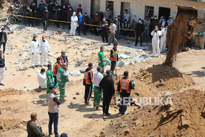 Anggota kru dari kementerian kesehatan, keadilan, dan pekerjaan dalam negeri Palestina di antara puing-puing Kompleks Rumah Sakit Medis Al-Shifa di Kota Gaza, (8/4/2024).