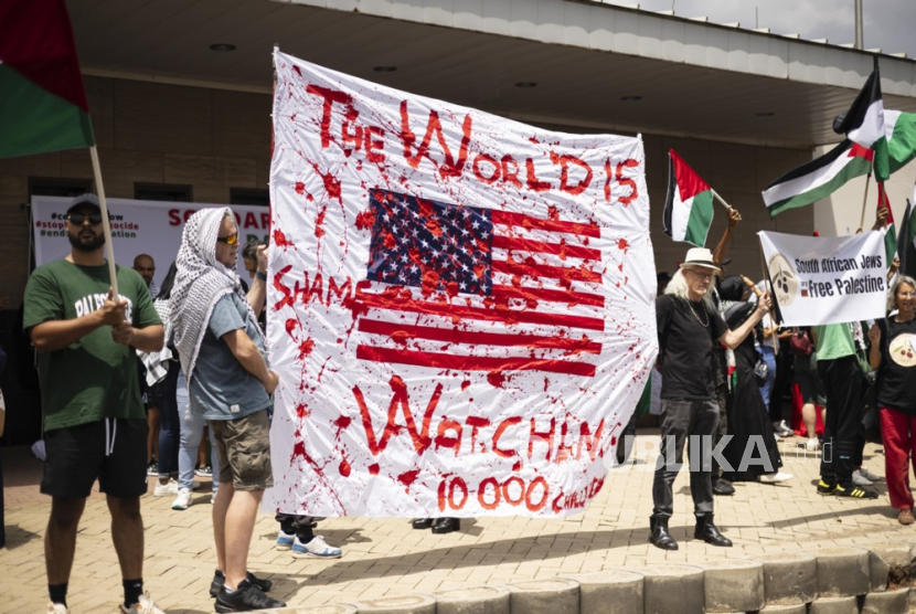 Pengunjuk rasa membawa plakat saat protes kemerdekaan Palestina di Konsulat AS sebagai aksi global mendukung Palestina merdeka, di Johannesburg, Afsel, (13/1/2024).
