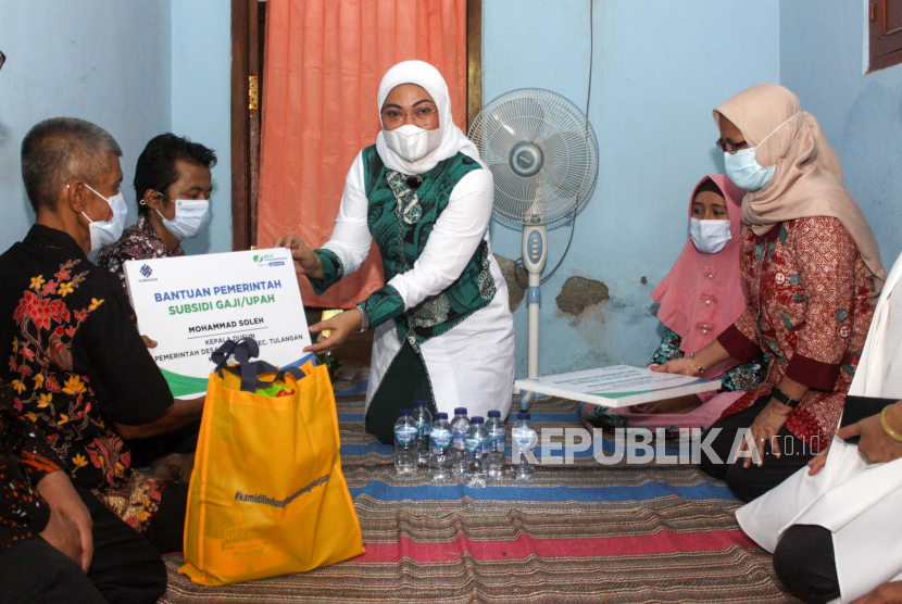 Menteri Ketenagakerjaan Ida Fauziyah (tengah) menyerahkan bantuan kepada warga di Desa Grinting, Tulangan, Sidoarjo, Jawa Timur, Jumat (6/11/2020). Kunjungan tersebut dalam rangka melihat secara langsung penyaluran sembako dan Bantuan Subsidi Upah (BSU) untuk pekerja atau buruh penerima upah/gaji dan terdaftar sebagai peserta aktif program jaminan sosial ketenagakerjaan BPJS Ketenagakerjaan/BP Jamsostek. 