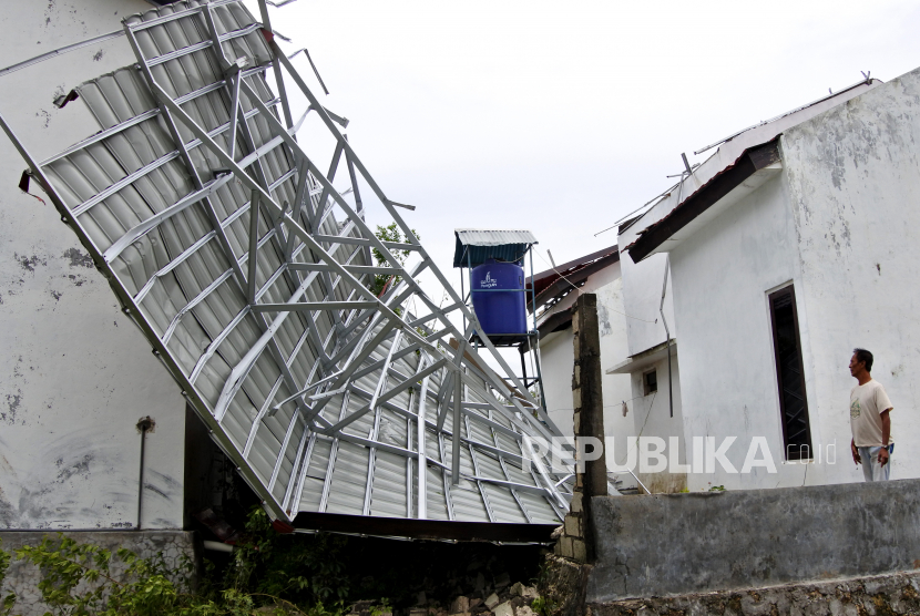 Seorang warga melihat atap rumahnya yang jatuh akibat diterjang angin kencang (ilustrasi)