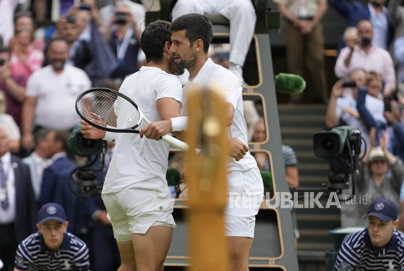Petenis asal Spanyol Carlos Alcaraz menyapa petenis Serbia Novak Djokovic (kanan) setelah pertandingan final tunggal putra kejuaraan tenis Wimbledon di London, Inggris, Senin, (17/7/2023).