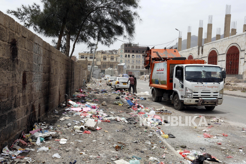 Pekerja kebersihan membersihkan sampah dari jalan di tengah penyebaran epidemi Covid-19 , di Sanaa, Yaman. ilustrasi