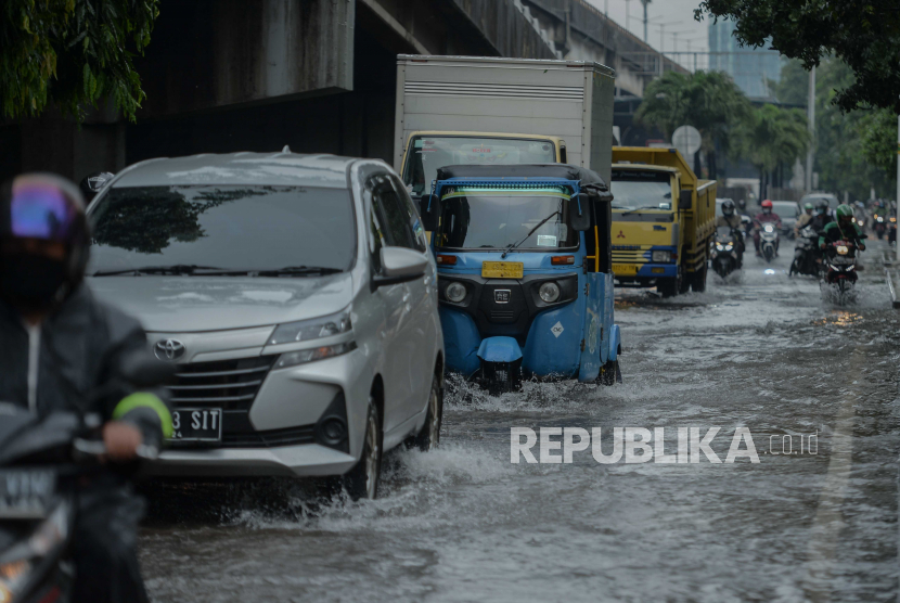 Pengendara melintasi genangan air di jalan protokol Yos Sudarso, Sunter, Jakarta Utara, Selasa (16/2). Genangan setinggi 20-40 sentimeter tersebut akibat luapan saluran darinase setelah curah hujan tinggi pada pagi hari. Republika/Thoudy Badai